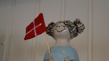 En keramisk figur med blå bund og rødt flag.