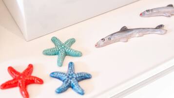Une surface blanche ornée de quatre étoiles de mer et de deux jouets en forme de poisson.