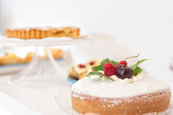 A dessert with whipped cream and berries on a clear glass plate. - Sersale Suites (Sorrento)