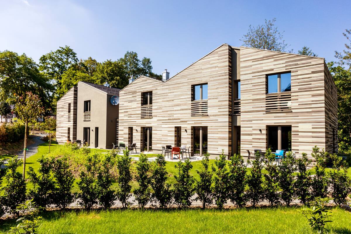 Un edificio moderno de varios pisos con techo plano y paneles de madera horizontales.