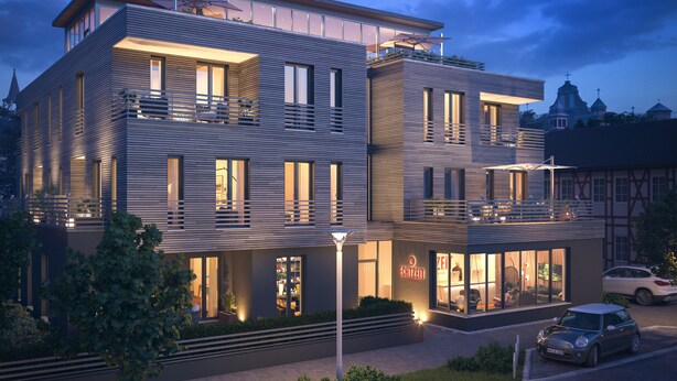A modern multi-story building with balconies, large windows, and a well-lit facade. - EchtZeit - Dein Hotelquartier (Braunlage)