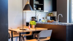 A modern kitchen with a wooden table, a hanging pendant light, and a built-in microwave. - EchtZeit - Dein Hotelquartier (Braunlage)