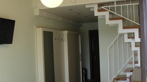 A bedroom with a large bed, a staircase, and a hanging light fixture. - Pension Krämerhof Kulz (Thanstein)