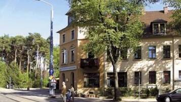 A building with a traditional architectural style, featuring a ground floor with a shop and upper floors with residential units.