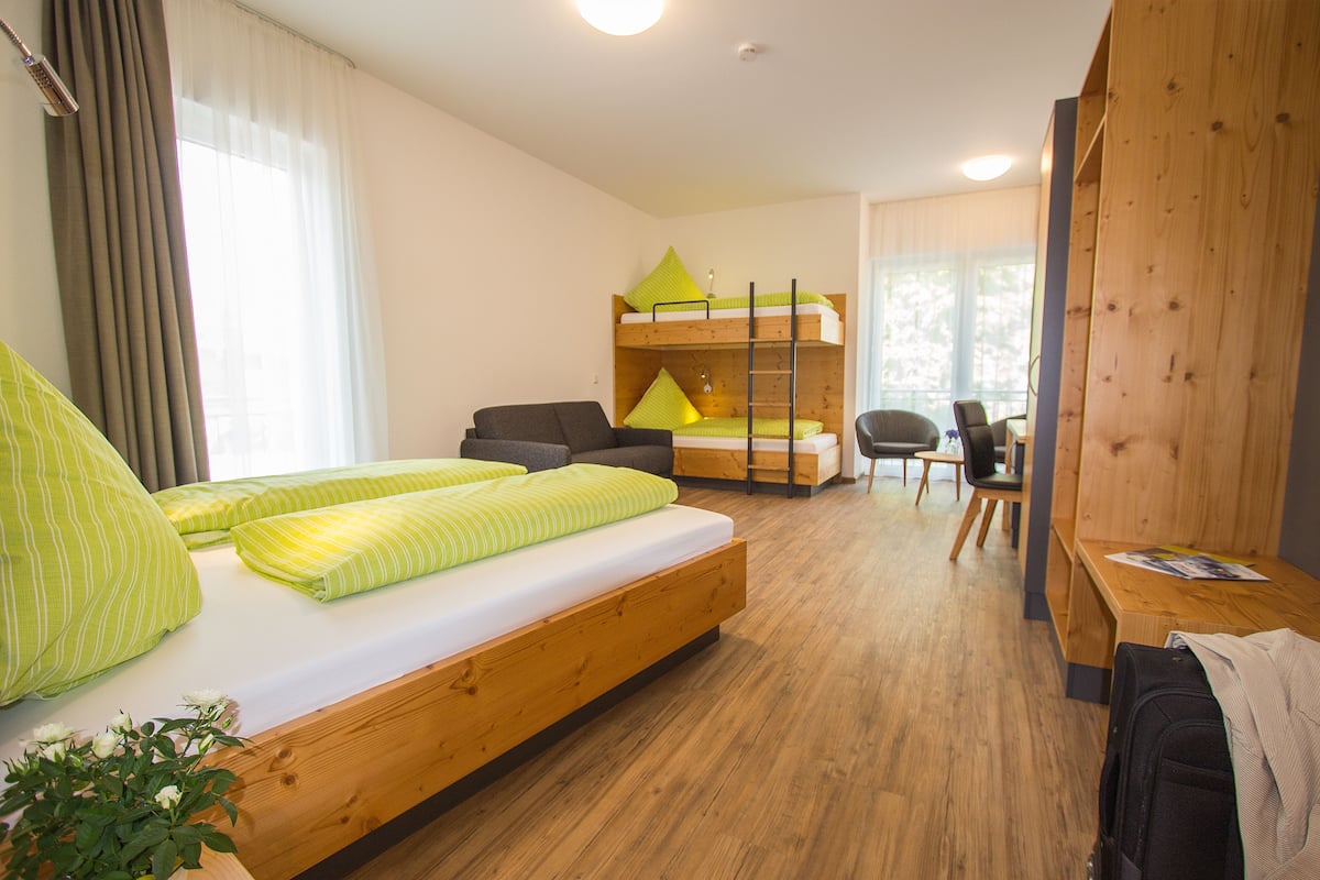 Une chambre moderne avec un lit superposé, un bureau, une chaise et une plante en pot.