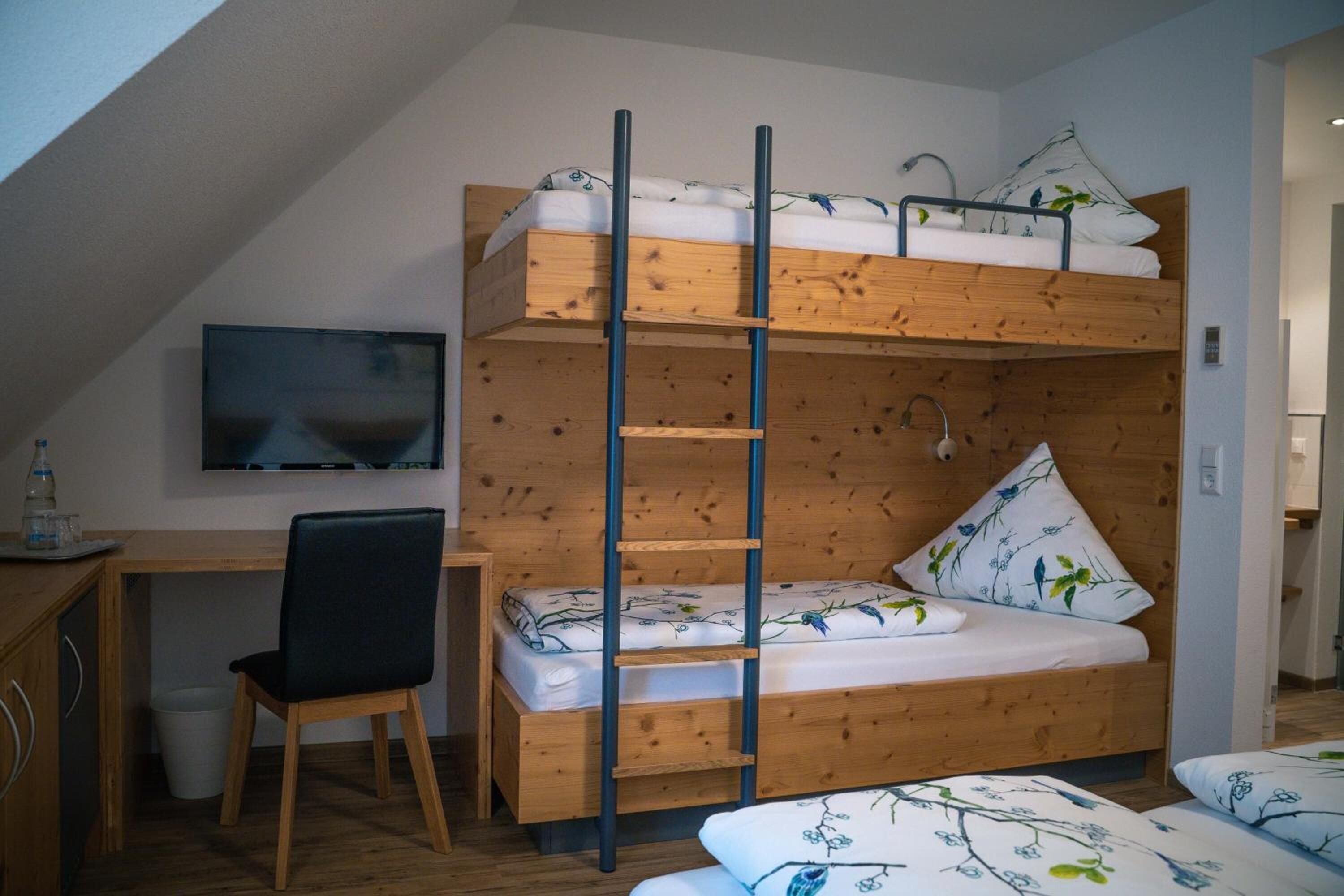 Ein Schlafzimmer im Loft-Stil mit Etagenbett, Schreibtisch und Stuhl.