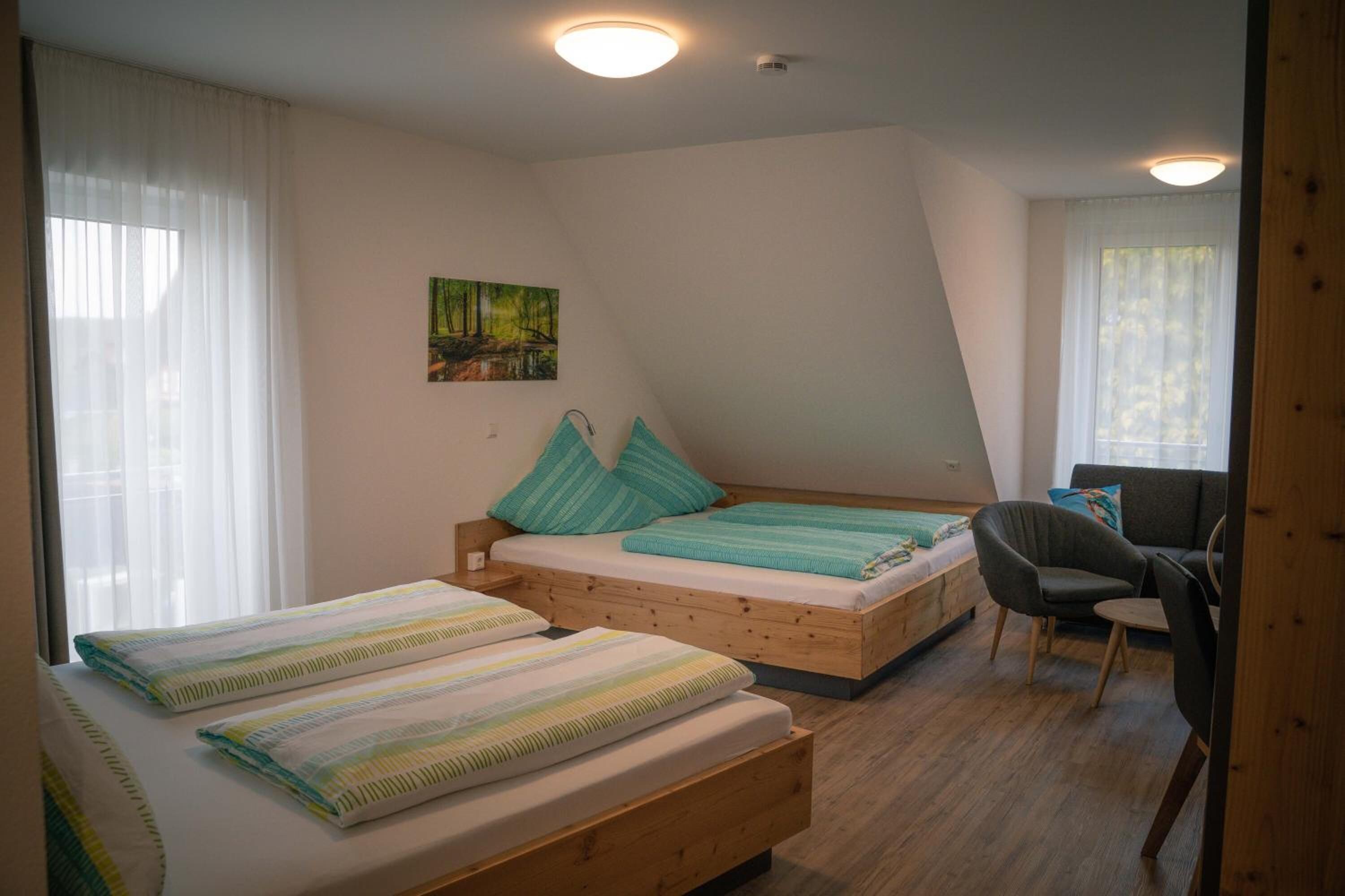 A bedroom with two beds, a desk, and a chair.