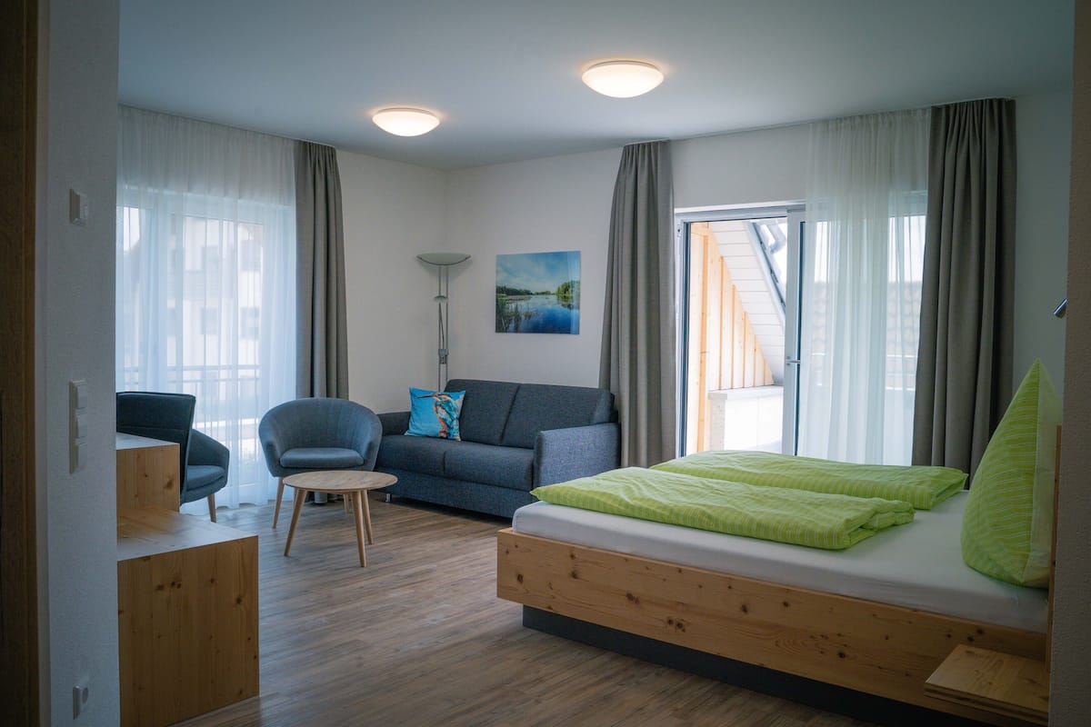 Une chambre moderne avec un lit, un canapé, une chaise et un bureau.