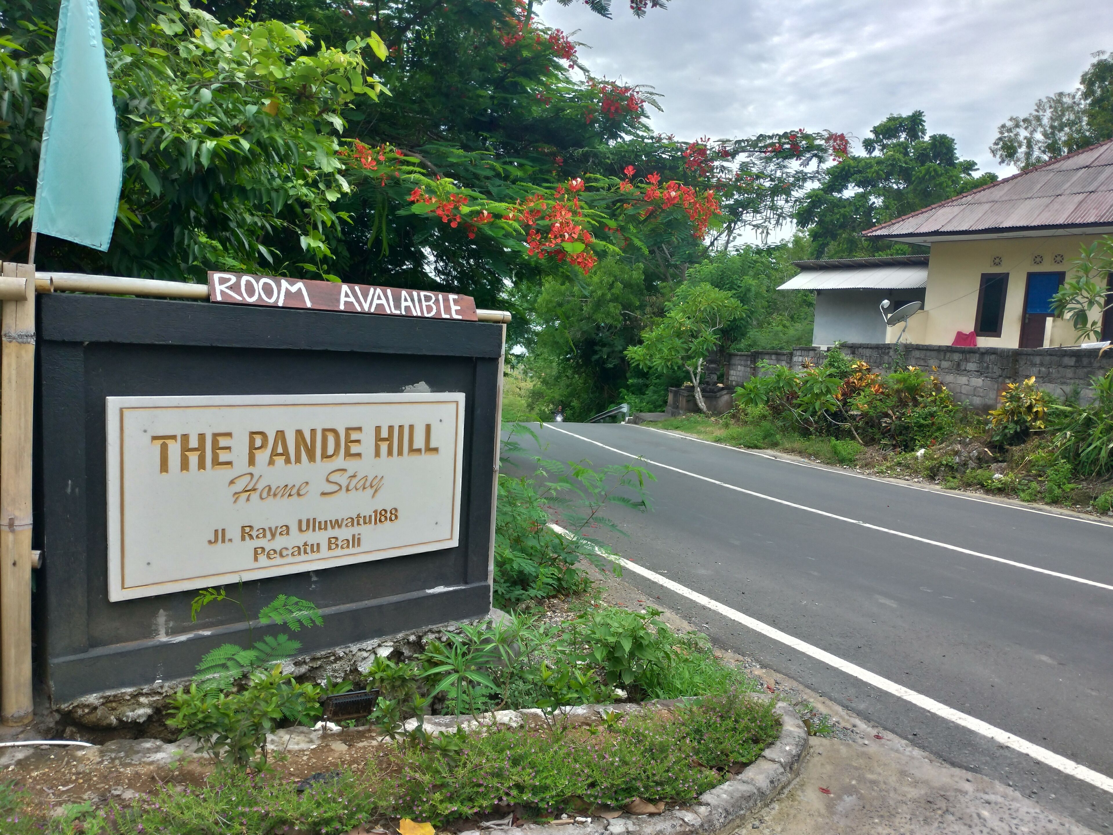 Segnaletica per The Pande Hill House Stay, con una strada sullo sfondo.