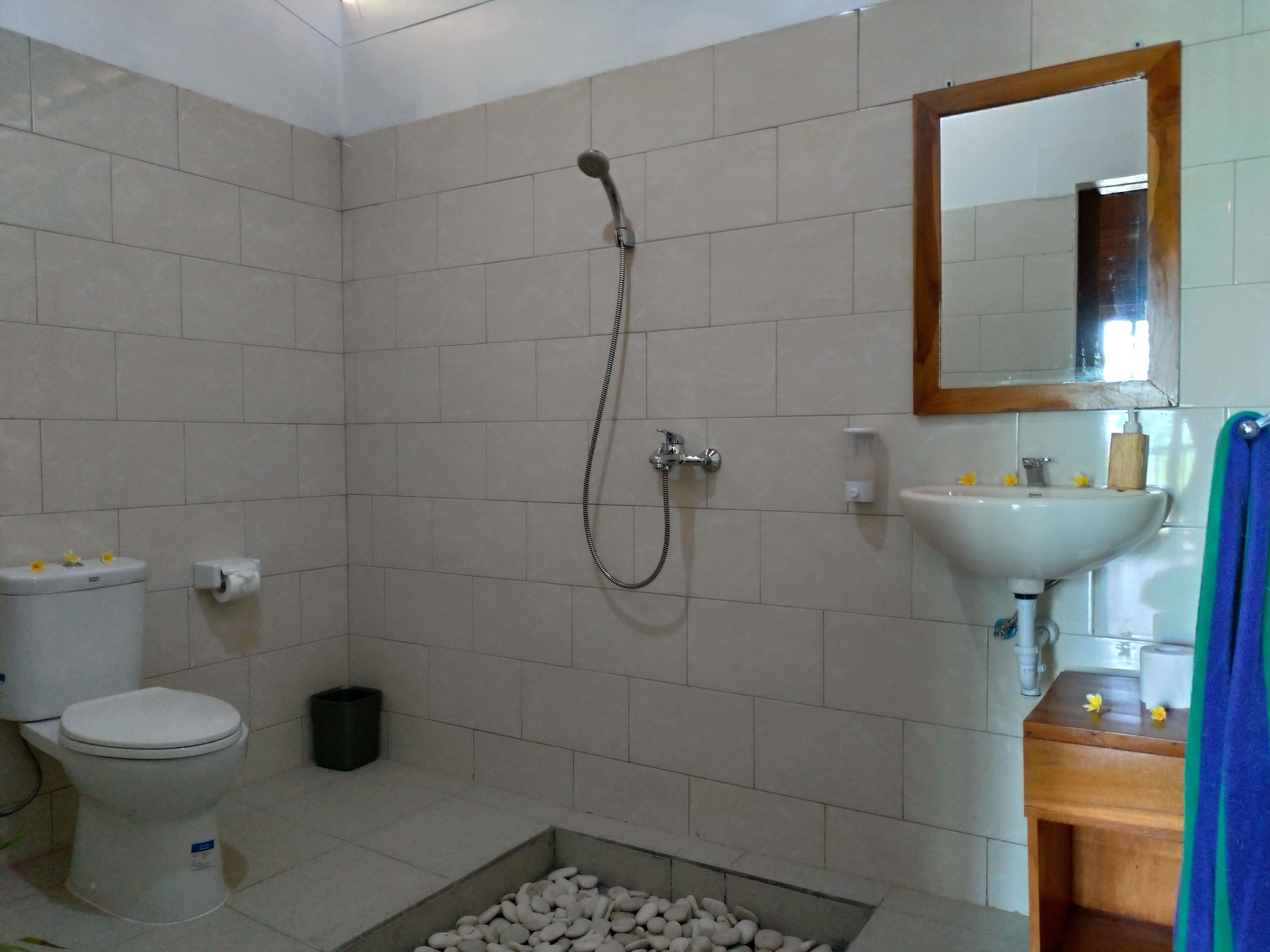Un baño con ducha, inodoro, lavamanos y espejo.