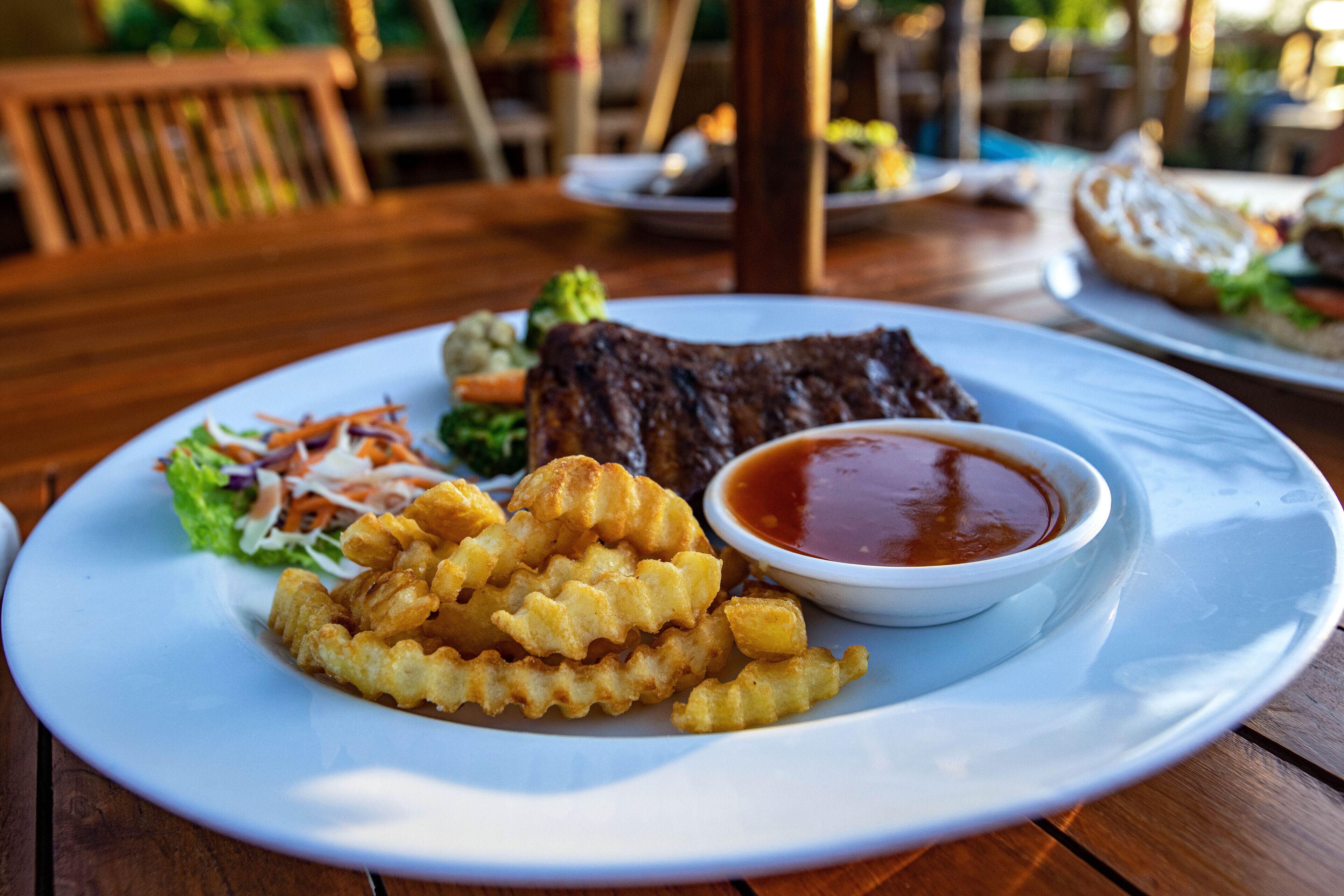 Un plato de comida con un bistec, papas fritas y una ensalada.