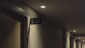 Corredor com portas numeradas 2.08 e 2.06, indicando um hotel ou prédio de apartamentos.
