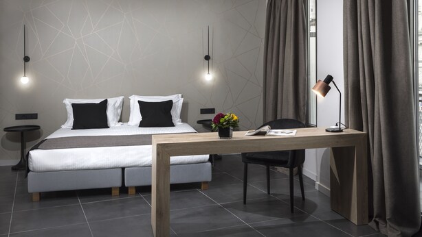 A modern bedroom with a bed, bedside tables, a desk, and a chair. - Azur Suites (Glyfada)