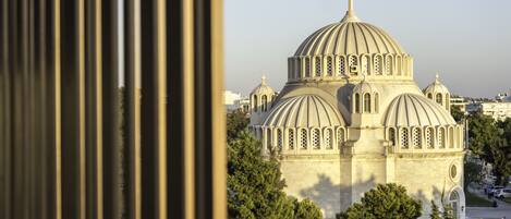 A view of a large, multi-dome building with a prominent central dome and smaller surrounding domes, surrounded by trees and other buildings.