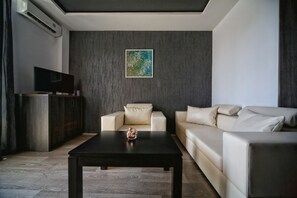 Suite, balkon (202, 302) | Woonkamer | Een flatscreentelevisie