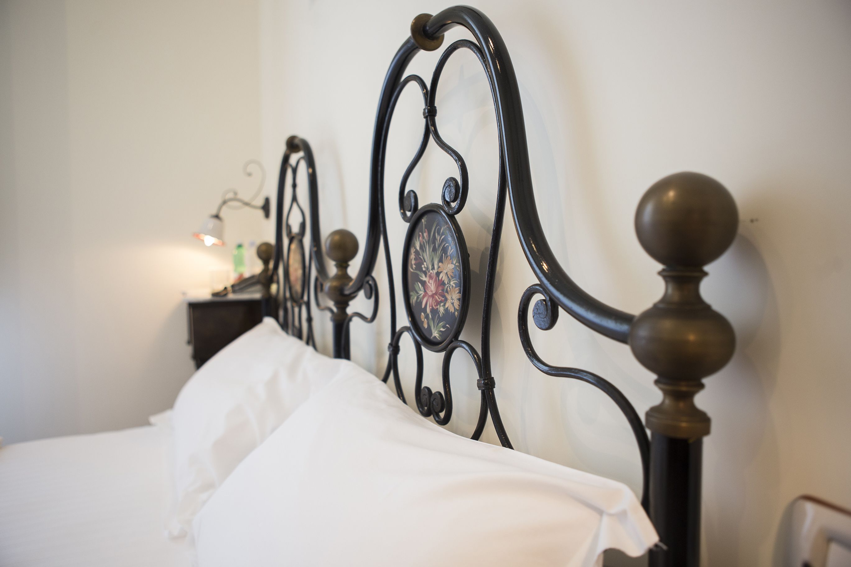 A bed with a black metal headboard and a decorative panel.