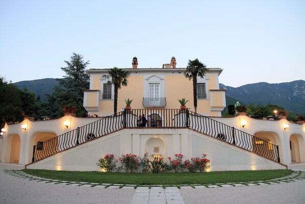 A grand building with a prominent staircase, a balcony, and a well-maintained garden. - Tenuta Torellone (San Potito Sannitico)