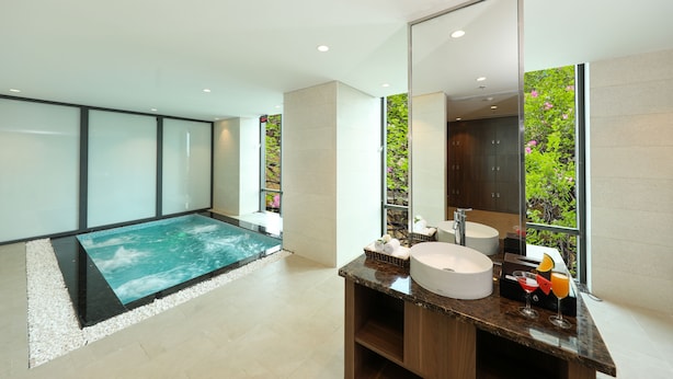 A modern bathroom with a large mirror, a bathtub, and a sink. - Grand Vista Hanoi (Hanoi)