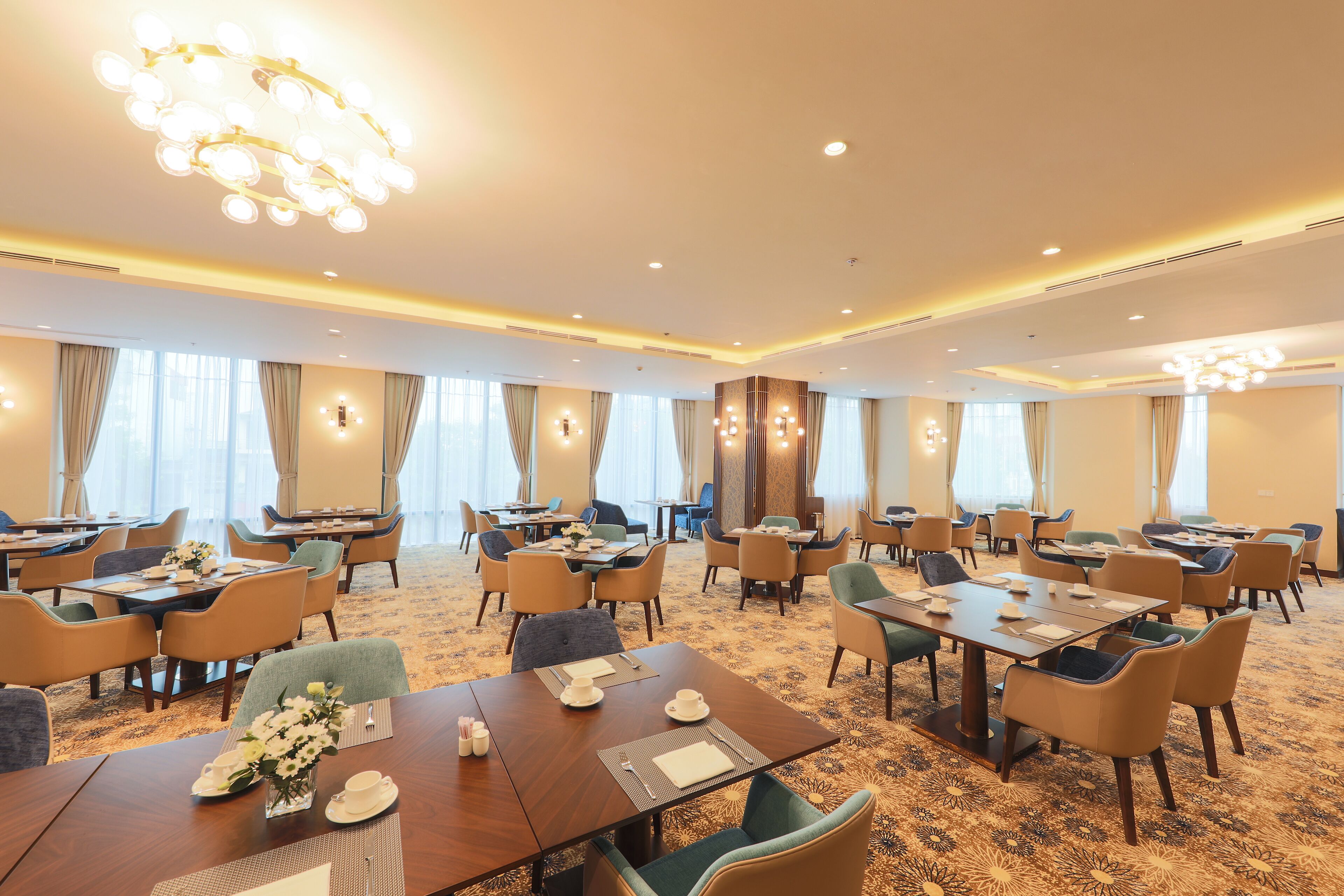 Ein Hotel-Speisesaal mit mehreren Tischen und Stühlen, ansprechend aufgeteilt.