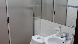 A modern bathroom with a toilet, sink, and glass shower enclosure. - New apartment, 1A center of Villarrica (Villarrica, Araucania)