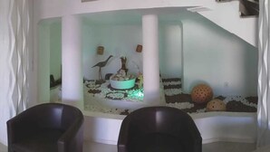 A room with a white wall, a white column, and a white floor. There is a white chair in the foreground. - Hotel Mirante (Euclides Da Cunha)