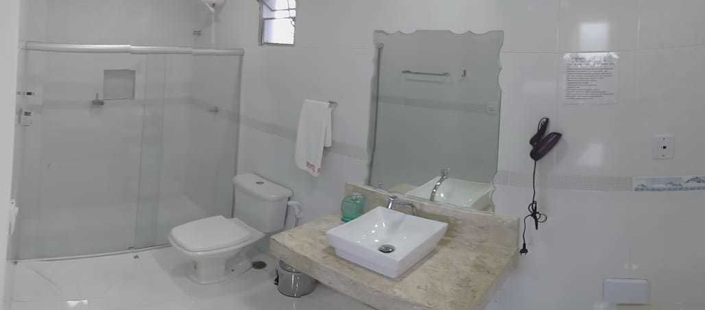 Un baño con ducha, inodoro, lavamanos y espejo.