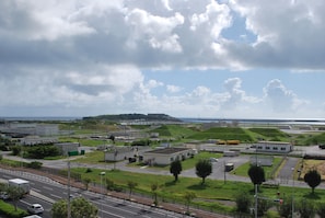 Zona industrial con edificios, caminos y una colina distante.