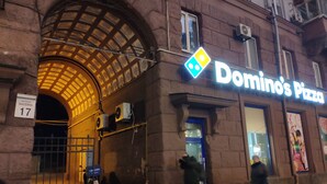 Un edificio con una entrada grande y arqueada, un letrero de Domino's Pizza y el número 17 visible.