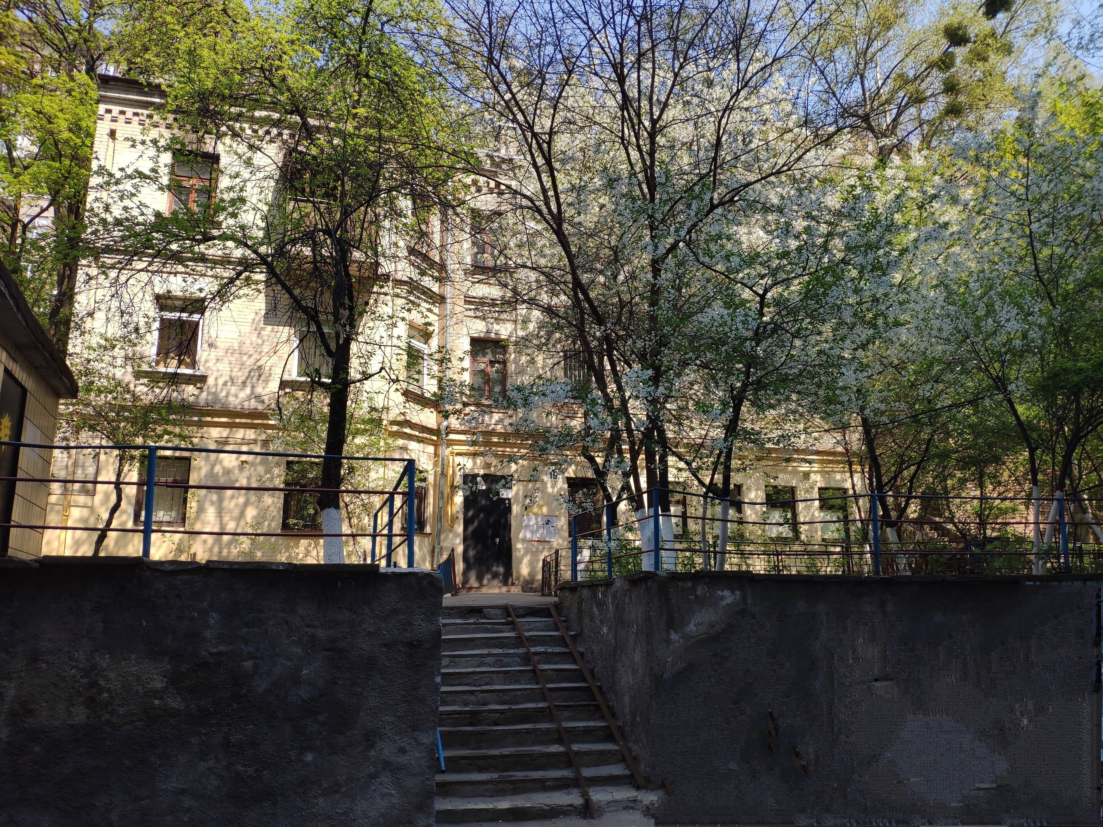 A staircase leading to a building with multiple windows and a gate.