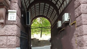 Un pasaje en arco con un muro de piedra, una reja metálica y un cartel que indica la ubicación como BASELINA 17.