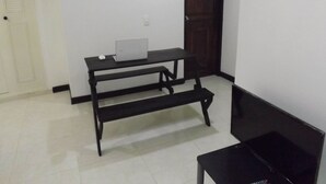 A room with a black desk, a laptop, and a television. - Edificio Angelo (Cartago)