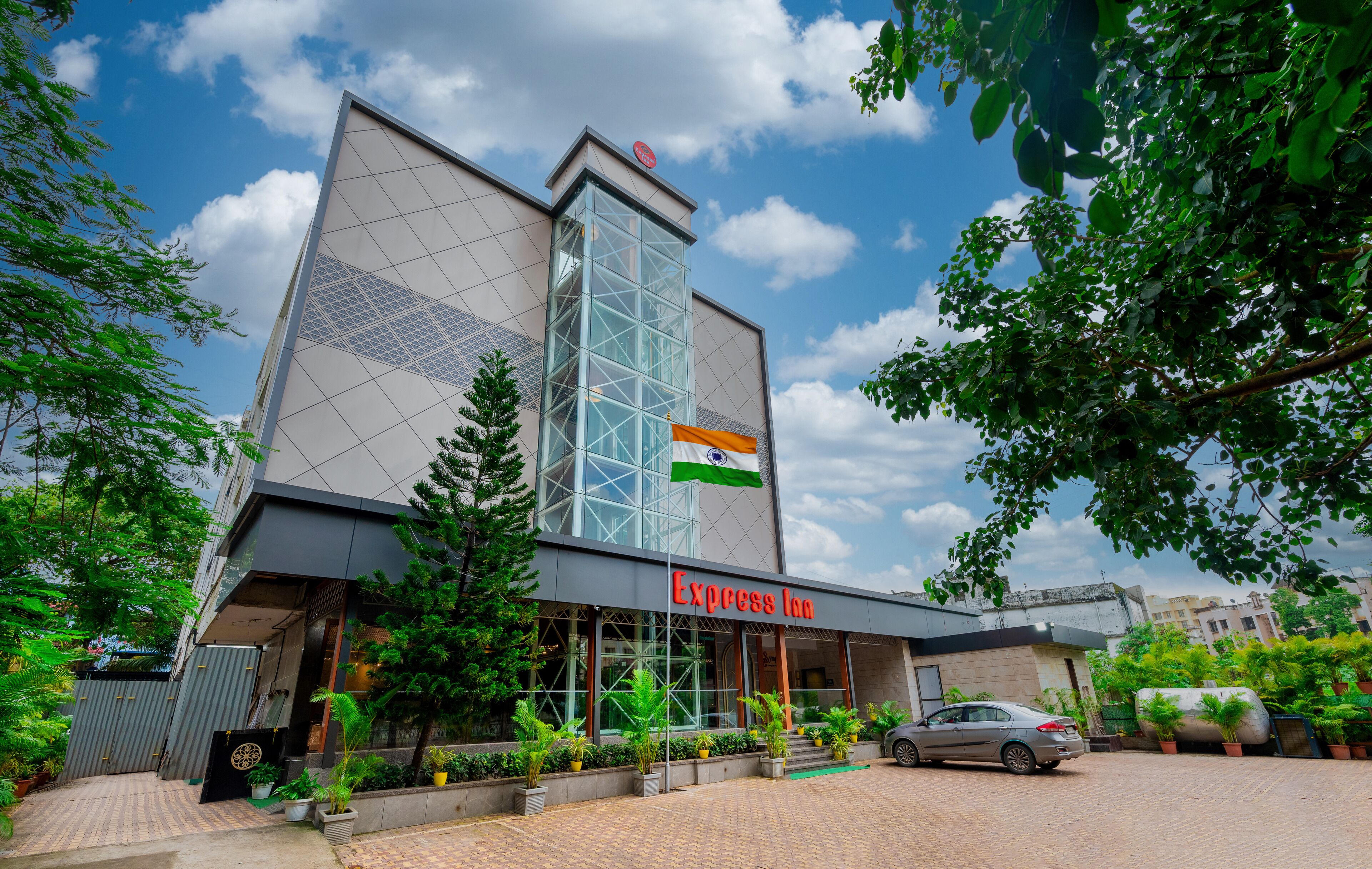 A modern building with a glass facade, a flag, and the name "Express Inn" on the front.