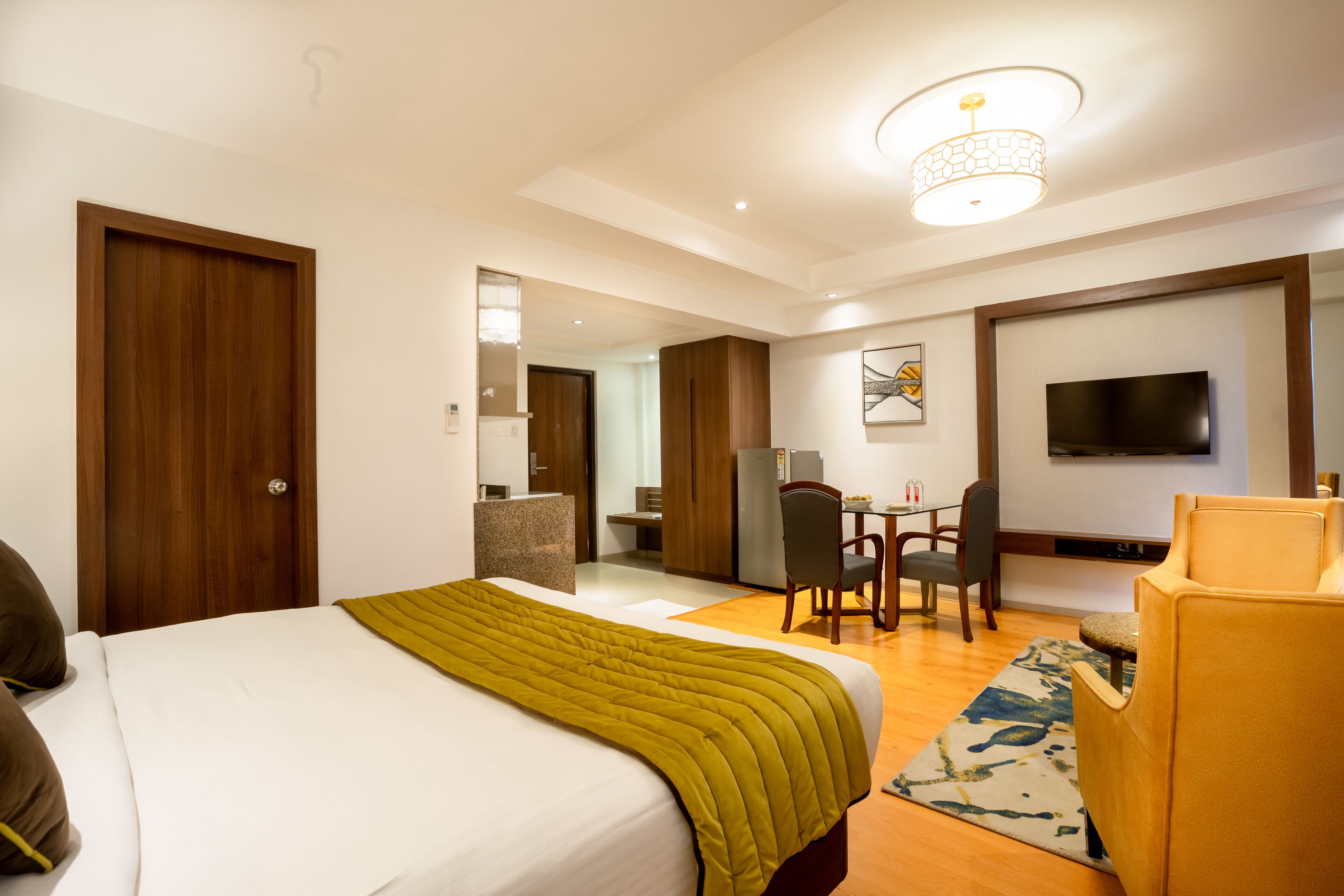 A hotel room with a bed, a desk, a chair, a television, and a mirror.
