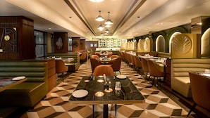 A restaurant with booths, tables, and a checkered floor. - Freesia by Express Inn (Palghar)