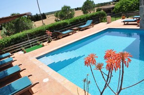 Alberca al aire libre, sombrillas en la alberca y camastros 