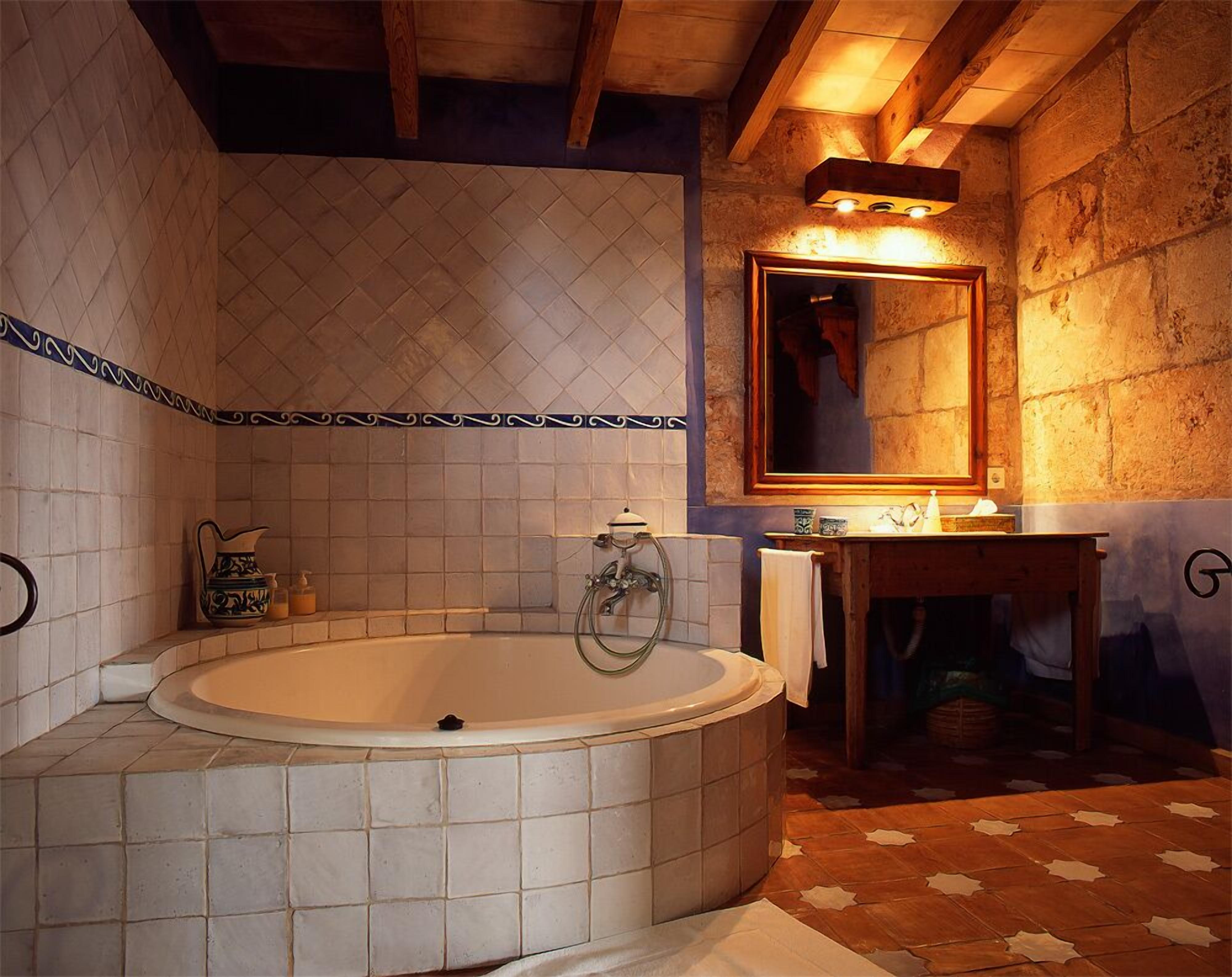A bathroom with a freestanding bathtub, a mirror, and a small vanity with a towel.