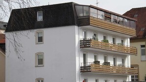 A multi-story building with balconies, a flat roof, and a visible antenna. - Hotel Humboldt (Bad Kissingen)