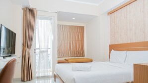 Una habitación de hotel moderna con una cama de madera, un televisor y un amplio ventanal con cortinas.