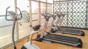 Un gimnasio con cintas de correr y una máquina elíptica.