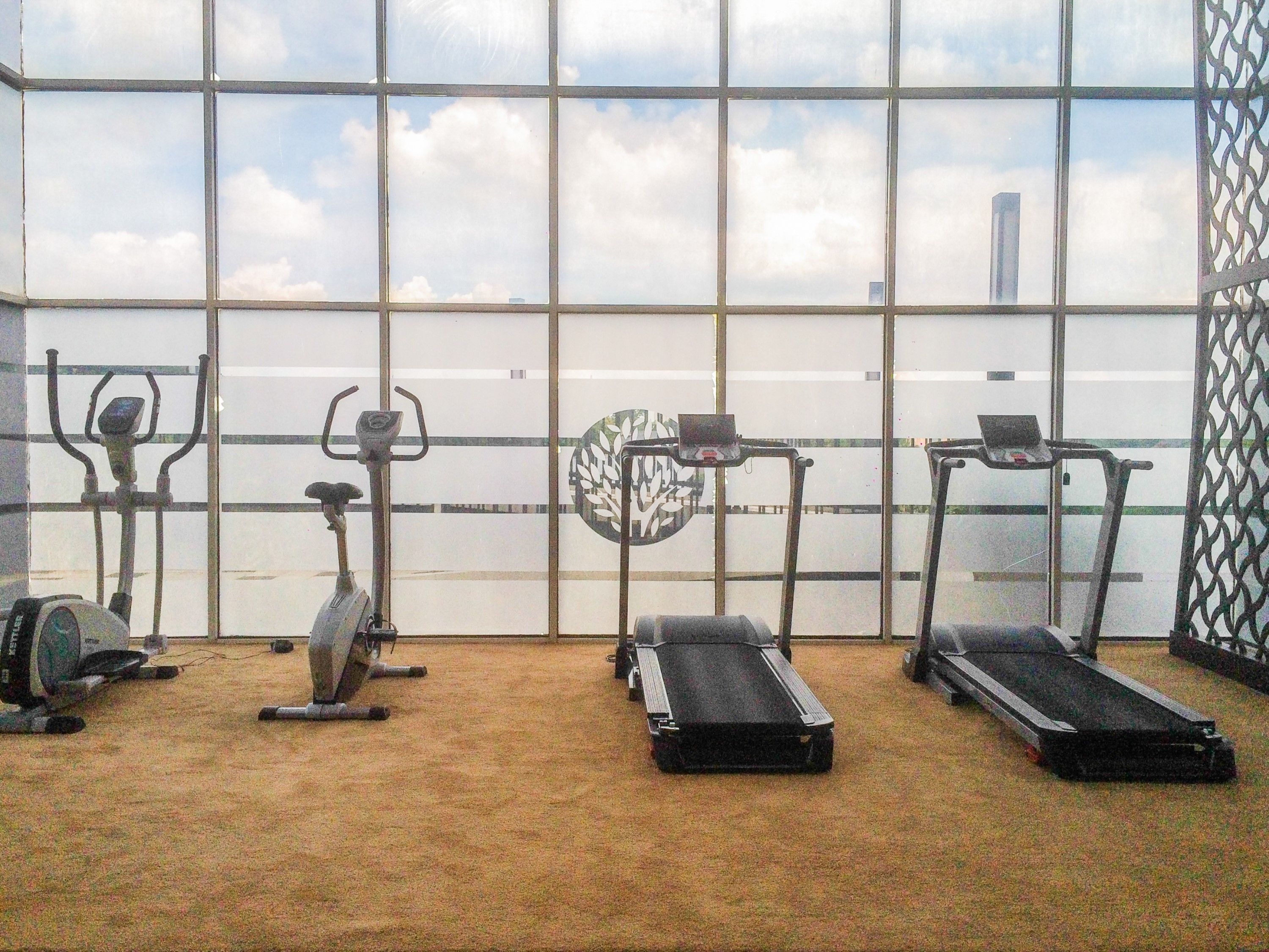 Un gimnasio con bicicletas estáticas, elíptica y cintas de correr.