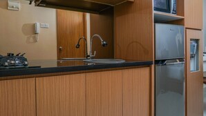 Una cocina moderna con armarios de madera, un refrigerador de acero inoxidable y un microondas empotrado.