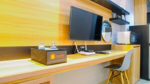 Een moderne keuken met een houten aanrecht, een flatscreen televisie, een koelkast en een reisservicebox met de naam 'Travello'.