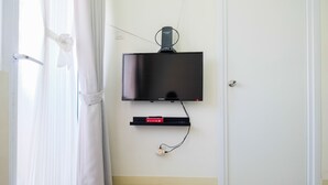 Ein Flachbildfernseher an der Wand, darunter eine Steckdosenleiste.