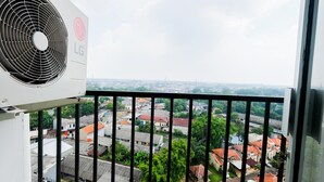 Ein Balkon mit Blick auf eine Stadtlandschaft, eine LG-Klimaanlage und ein Metallgeländer.