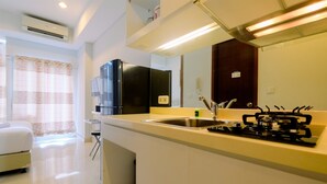 Una cocina moderna con estufa integrada, lavamanos y microondas sobre la encimera.