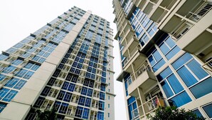 Un edificio residencial alto, con varios balcones y ventanas grandes.