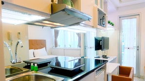 A modern kitchen with stainless steel appliances, a black countertop, and a built-in oven.