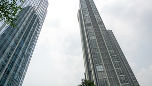 Two tall, modern skyscrapers with reflective glass facades, viewed from a low angle looking up. - Comfy Studio Ciputra International Apartment (Jakarta)