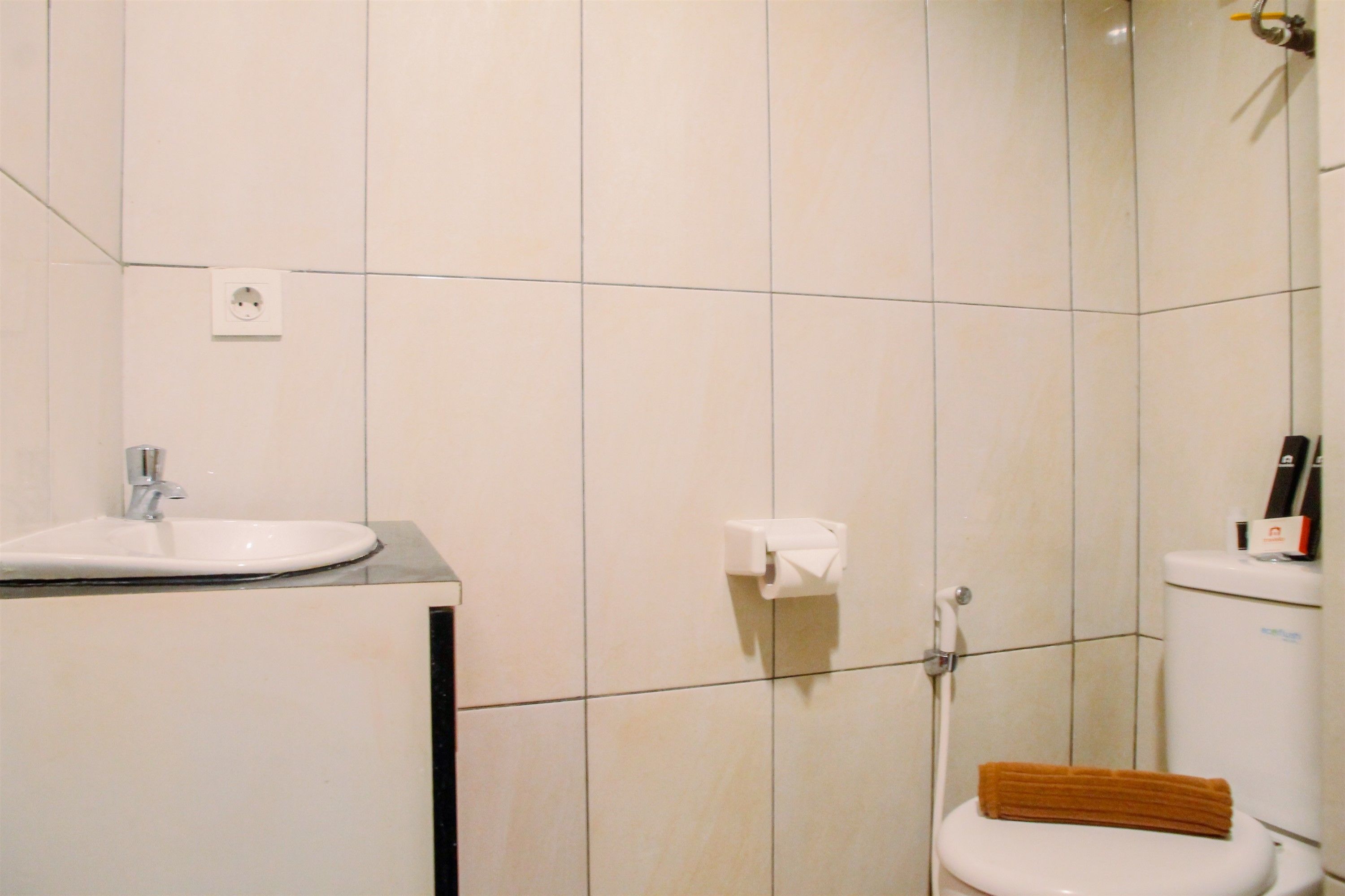 Une salle de bain équipée d’un lavabo, de toilettes et d’un porte-serviettes.