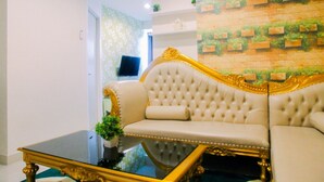 Une chambre luxueuse avec un canapé moelleux, une table basse en verre et un mur décoré d’un motif en briques.